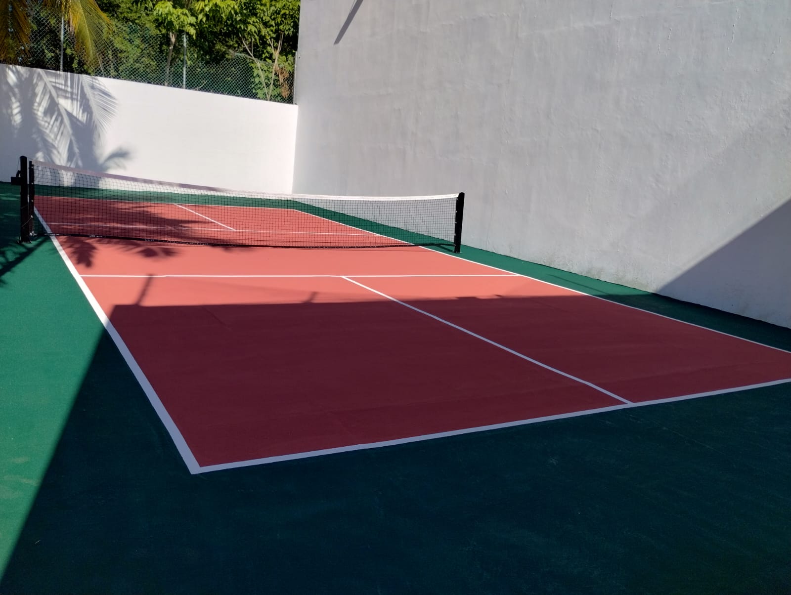 Cancha de pickleball roja construida por CanchasdePickleball.mx en residencia privada de Cancún con pintura acrílica antiderrapante